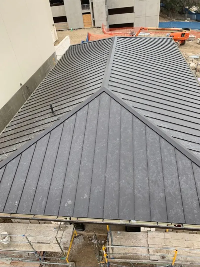 Commercial metal roof construction with crane equipment in Glen Burnie